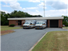 A brick building with two ambulances parked out front.