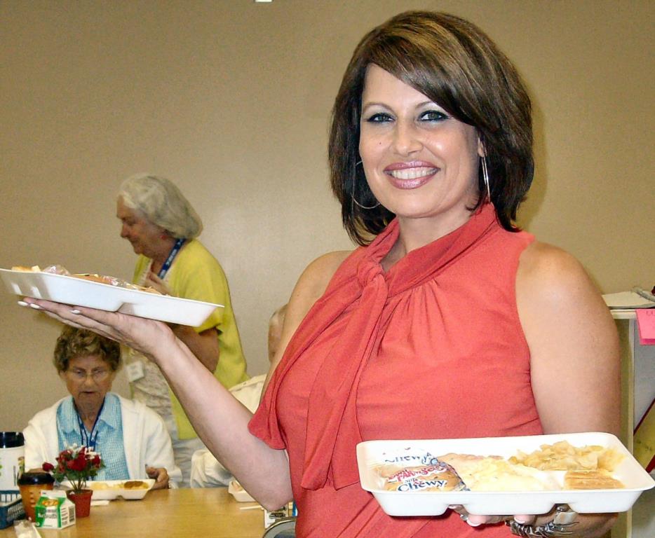 Thessia Everhart-Roberts, helps serve lunch to the Nutrition Site